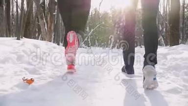 青年男女在冬林中奔跑.. 早上好。 雪从鞋底飞出